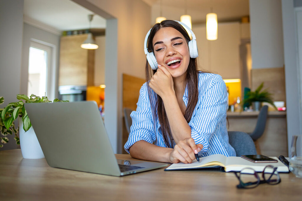 woman smiling listening on computer